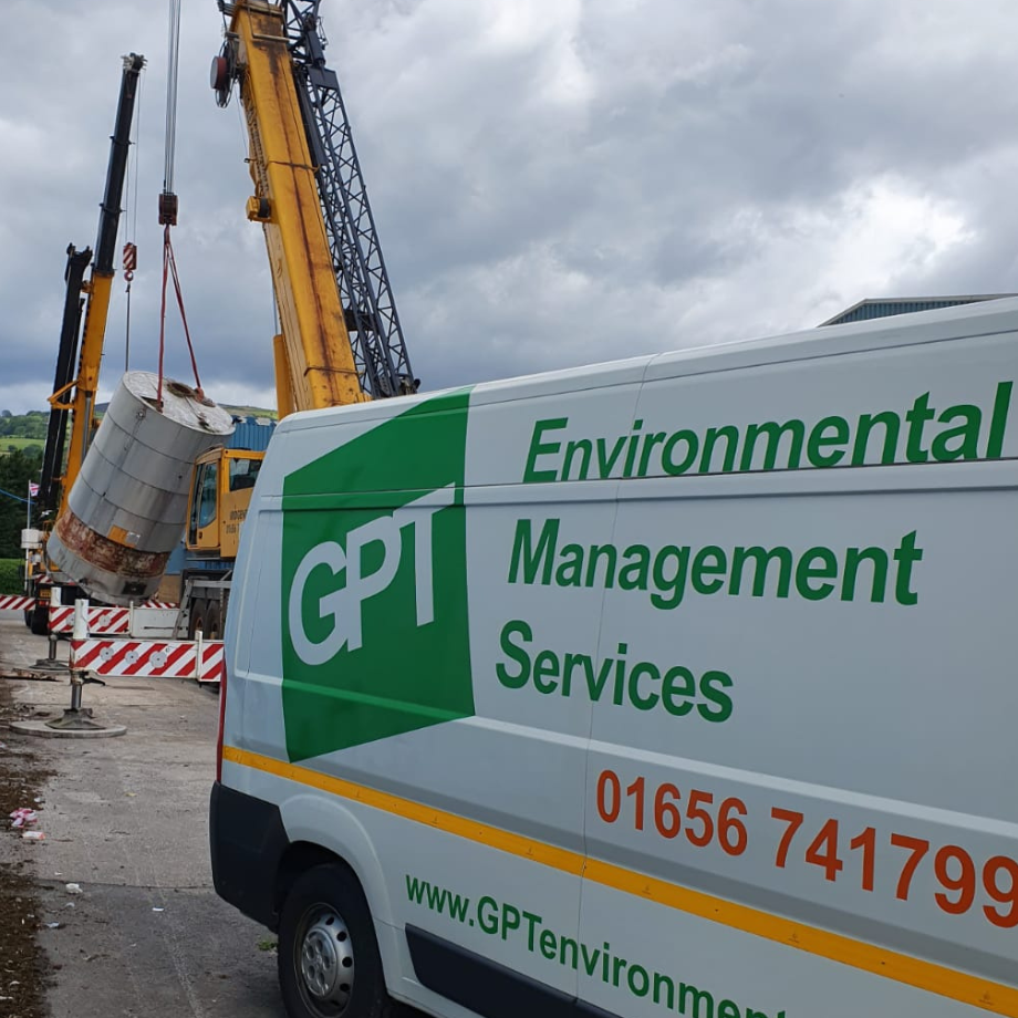 large oil tank being lifted and removed with gpt van in foreground