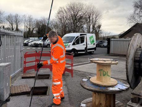 gpt field engineer wearing orange hi vis taking water sample from an interceptor